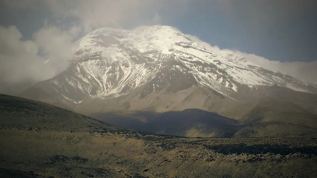Macizo volcánico entre nubes en la cordillera andina